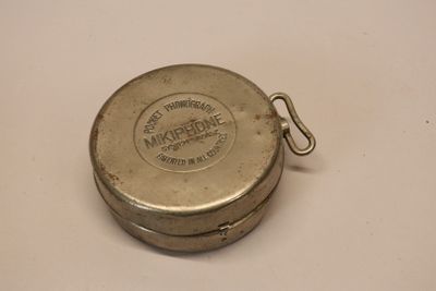 a small metal container with a metal handle on a table