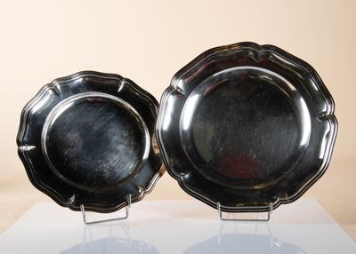 two silver plates that are sitting on a table