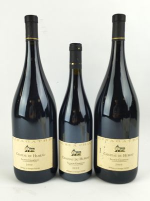 trois bouteilles de vin posées les unes à côté des autres sur une surface blanche