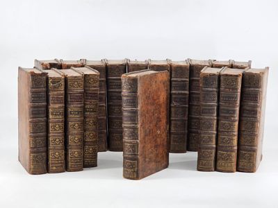 several old books stacked on top of each other on a white surface