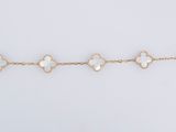 un bracelet en or orné de quatre breloques en forme de trèfle sur fond blanc