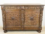 une vieille armoire en bois avec des sculptures et des gravures sur les portes