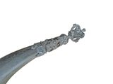 a large metal object with a long handle on a white surface