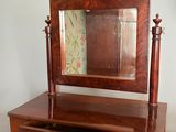 une petite coiffeuse en bois surmontée d'un miroir