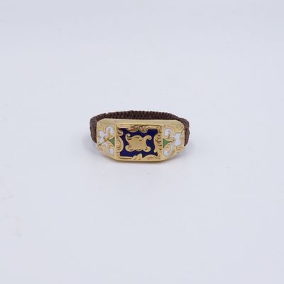 gros plan d'une bague en or avec une pierre bleue au centre