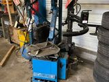 a machine that is sitting in a garage with a tire