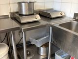 two sinks in the kitchen with pots and pans on them