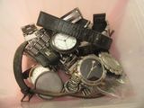 un bac en plastique rempli de montres diverses et variées