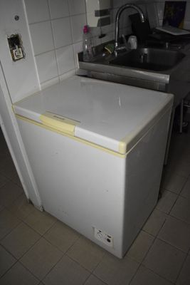 un petit réfrigérateur blanc dans une cuisine équipée d'un évier