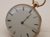 une montre de poche en or avec des chiffres romains sur le cadran
