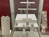 a glass display case with a cross on top of it