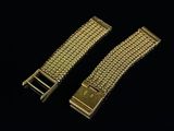 a pair of gold metal bracelets on a black background