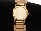 a gold watch sitting on a black velvet cushion