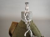 a bottle with a chain attached to it