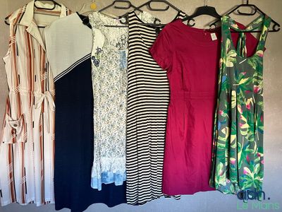 un grand nombre de robes suspendues à une étagère dans une pièce