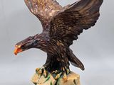 une image représentant une statue d'aigle au sommet d'un rocher