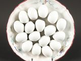 un bol blanc contenant des œufs, posé sur une surface noire