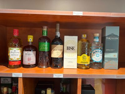 de nombreuses bouteilles d'alcool sur une étagère dans un magasin