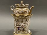 a white and gold teapot with a painting on it