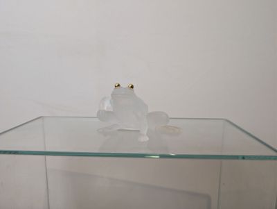 a glass table with a glass frog on it