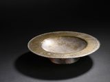 an image of a silver bowl sitting on a black surface