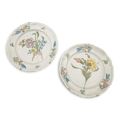 two white plates with floral designs on them on a white surface