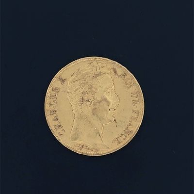 a close up of a gold coin on a black surface
