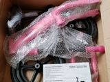 a pink bike in a cardboard box with a pink handlebar
