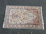 a rug on the ground next to a pair of scissors