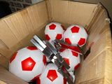 a box full of red and white soccer balls in it