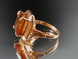 a gold ring with an orange stone in it