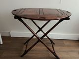 une petite table en bois sur laquelle reposent deux pieds croisés