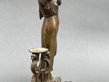 bronze statue of a woman holding a mirror and a dog