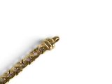 a close up of a gold bracelet on a white surface