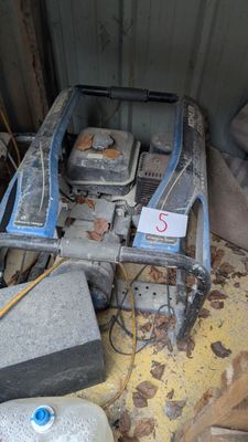 une machine qui trône au milieu d'un tas de ferraille