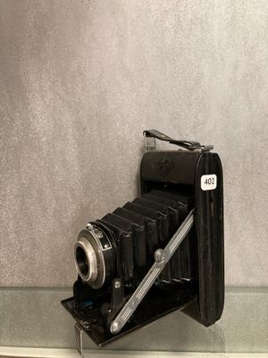 un appareil photo noir posé sur une étagère en verre près d'un mur