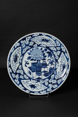 a blue and white plate with a design of flowers and birds on it