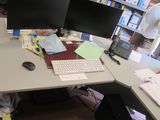 un bureau sur lequel sont posés deux écrans d'ordinateur et un clavier