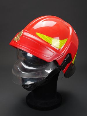 un gros plan sur un casque de pompier rouge posé sur la tête d'un mannequin