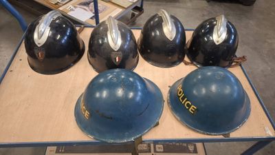 several helmets are lined up on a table in a warehouse