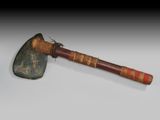 an old axe with a wooden handle sitting on top of a table