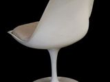a white chair that is sitting on a black surface