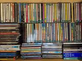beaucoup de DVD empilés dans une boîte posée sur une étagère