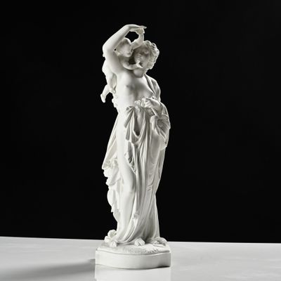 une statue représentant une femme tenant un bébé dans ses bras, posée sur un socle