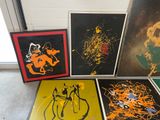 four framed art pieces of various colors and sizes on a floor