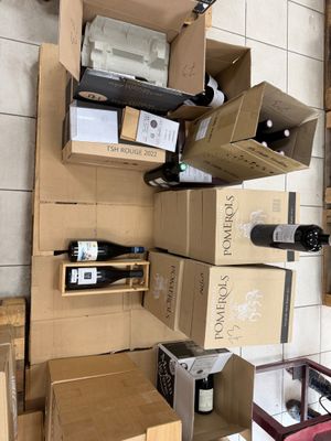 Plusieurs caisses de vin sont empilées les unes sur les autres dans une pièce