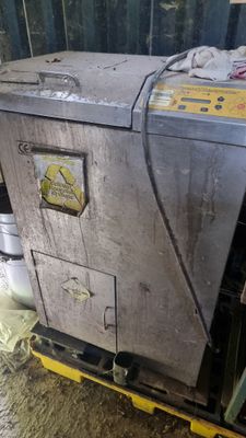une machine sale posée sur une palette dans une pièce