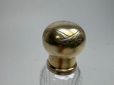 a small glass bottle with a gold top on a table