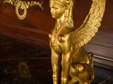 a gold statue of a cat sitting on a marble table