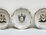 trois assiettes à motifs posées sur une surface blanche